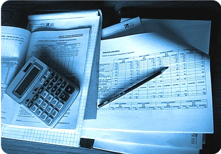 Libros contables, planillas y una calculadora sobre el escritorio