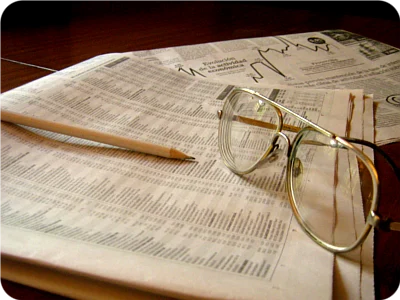 Anteojos y lápiz sobre las páginas económicas de un diario